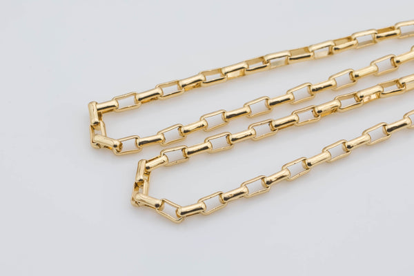 May include: Three gold chain necklaces with square links. The chains are layered on a white background.  The links are shiny and appear to be made of metal. The chains are delicate and have a uniform pattern. The image showcases the gold color and the rectangular shape of each link in the chain. The chains are suitable for layering or wearing individually as a necklace.