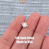 May include: A small, silver-colored charm in the shape of a sunburst. The charm has a series of pointed rays extending outward from a central circular area. Two small loops are on either side of the charm. The text &#39;14K Gold Filled Made in USA&#39; is printed below the charm.