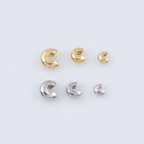 May include: Six C-shaped jewelry clasps in gold and silver tones are arranged on a white surface. The clasps vary in size, with three gold and three silver clasps. These findings are used in jewelry making.