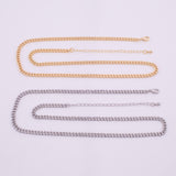 May include: Two necklaces: one gold-toned and one silver-toned. Both feature a curb chain design with an adjustable length. The gold necklace is positioned above the silver one, both resting on a white surface. The chains are made of metal.