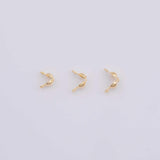 May include: Three small, gold-colored jewelry findings are arranged on a white background. Each finding has a curved shape with a small ball at one end and a loop at the other, suggesting they are clasps or connectors for jewelry making.