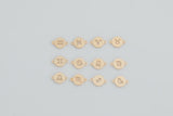 May include: Gold-colored zodiac charm pendants, each featuring a unique astrological symbol. The pendants are round with small loops on each side for attachment. The symbols include Aries, Taurus, Gemini, Cancer, Leo, Virgo, Libra, Scorpio, Sagittarius, Capricorn, Aquarius, and Pisces.