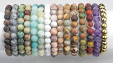 May include: A collection of 15 bracelets made with various natural stone beads. The bracelets feature different colors and patterns, including brown, gray, green, blue, white, pink, purple, and gold.