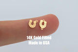 May include: Two gold-filled horseshoe charms, each with a small hole at the top for attaching to jewelry. The charms are shown on a finger, with the text "14K Gold Filled Made in USA" below them.