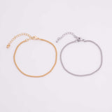 May include: Two delicate chain bracelets. One is gold-toned, the other is silver-toned. Each bracelet features a fine curb chain design and an adjustable clasp for a comfortable fit. The bracelets are displayed on a white background.